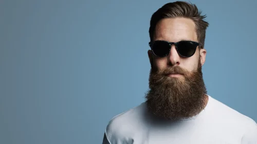 Man with beard and sunglasses on a blue background